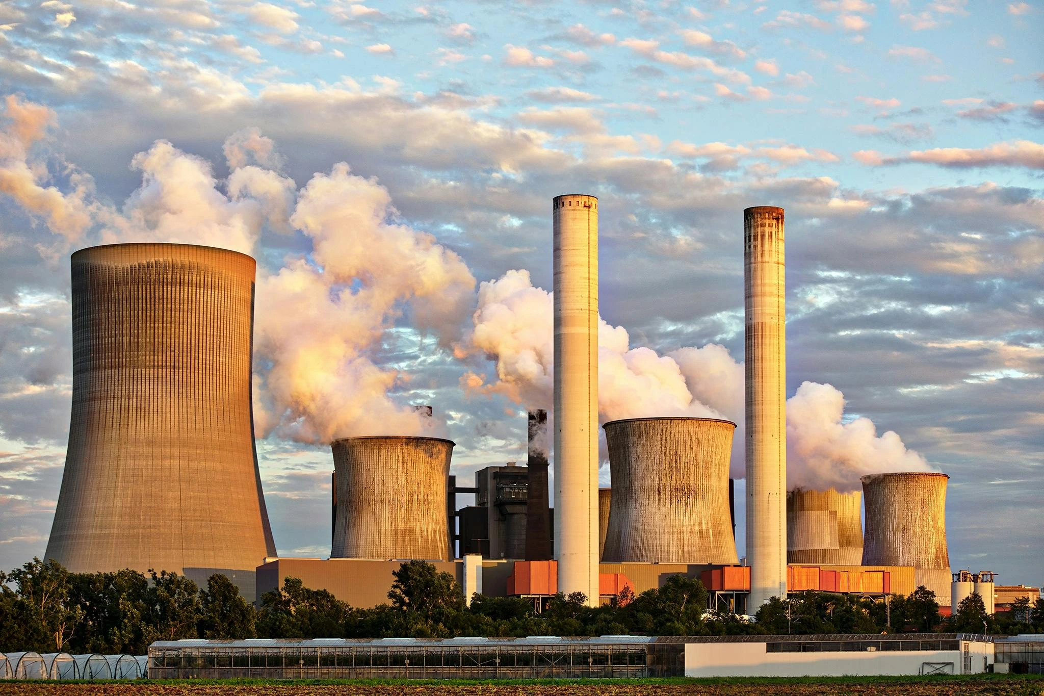 This image illustrates the environmental consequences associated with industrial technology, including air pollution from factory emissions. It highlights a critical aspect of the broader problems with technology in modern society, linking industrial processes to ecological concerns and climate change.
